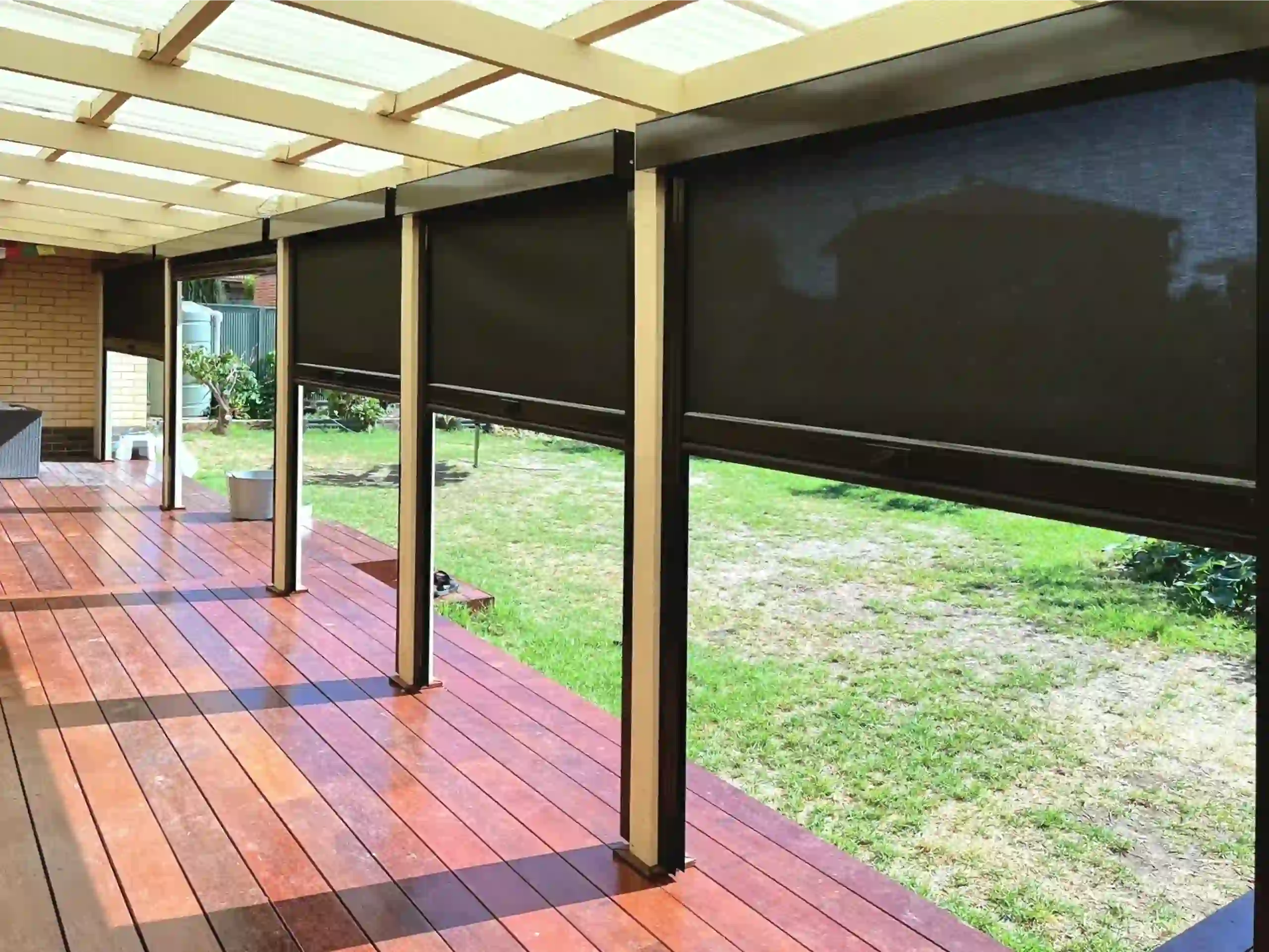Black outdoor blinds installed on a covered timber deck for shade and privacy